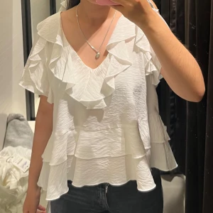 Vit volangblus med v-ringning - Vit blus med volanger från Zara. Helt oanvänd💗