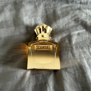 Scandal Absolu Pour Homme 100ml - Lyxig herrparfym från Jean Paul Gaultier, Scandal Absolu Pour Homme, 100 ml. Flaskan är fyrkantig med guldig finish och en unik kronformad kork. Parfymen har en djup bärnstensfärg och flaskan känns riktigt exklusiv och tung i handen. Köpte den för 2200kr