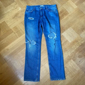 Blå slitna jeans   - Snygga blå jeans med slitningar och hål på knäna från Gina Tricot. perfect jeans. Raka ben och normal passform🩷