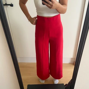 Vida kostymbyxor röda - Vida kostymbyxor, sparsamt använda. Jag är 157 cm lång och står på tå för referens. Hade skor så de inte släpa i marken.
