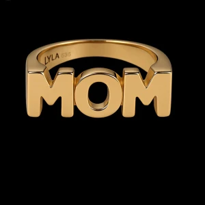 Mom ring  - Cool ring i guldfärg från LYLA med stora blockbokstäver som stavar 'MOM' framtill. Perfekt statement-piece för att hylla din mamma eller visa din stil. Ringen har en modern och chunky design som verkligen sticker ut.