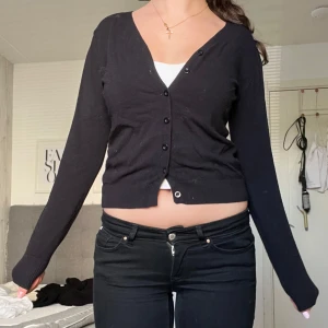Svart kofta  - Svart kofta med v-ringning och knappar framtill. Långärmad och i mjukt, tunt material som känns skönt mot huden💕