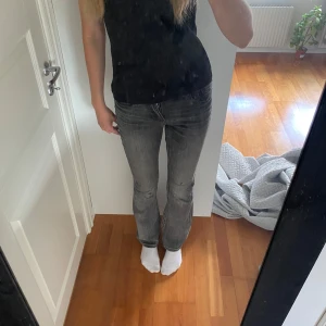 Grå bootcut jeans från Vero Moda  - Säljer ett par grå jeans med bootcut passform och snygg tvätt. Jeansen har klassisk femficksdesign och midwaist modell. Materialet är mjukt denim i bomull. Perfekta för dig som gillar en avslappnad men ändå trendig look. Lite slitet på knät.💕