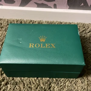 Klocka silver + grön - Hej! Säljer denna klocka därav batteriet är slut eller så är den sönder, men tror att det kan vara batteriet. Som du ser på sista bilden är själva glaset på klockan lite sönder men man ser ändå siffrorna.