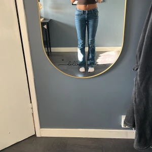Blå bootcut jeans med broderade fickor - Snygga blå bootcut jeans från Gina Tricot med låg midja och broderade detaljer på bakfickorna. Jeansen har klassisk femficksdesign, ljus tvätt och coola sömmar. Perfekta för dig som gillar en avslappnad men trendig look. Storlek 170
