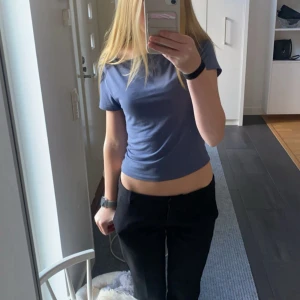 Blå croppad topp från Gina Tricot - Säljer en enkel och snygg blå croppad topp från Gina Tricot. T-shirten har korta ärmar och är i mjuk bomull. Super skönt material då den är i ginas soft touch serie.