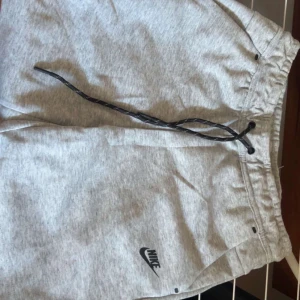 Gråa shorts från nike. - Säljer ett par grå nike tech shorts storlek M passar även S. Helt nya.