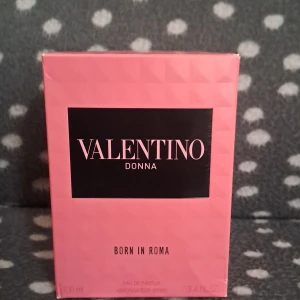 Valentino Donna Born In Roma EdP 100ml - Exklusiv parfym från Valentino, Donna Born In Roma. Flaskan är lyxigt designad i genomskinligt glas med nitar och svart kork. Förpackningen är rosa med svart etikett och text i rosa. Innehåller 100 ml Eau de Parfum.