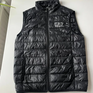 Svart väst från Emporio Armani  - Säljer nu min Armani väst u storlek M som jag knappt har använt. Den är i jättefint skick och inga märken.  Det följer även med en liten påse där du kan lägga i väste. Tveka inte att skicka om ni har några frågor. Köpte den för 1999kr. Kan gå ner i pris vid snabb affär.