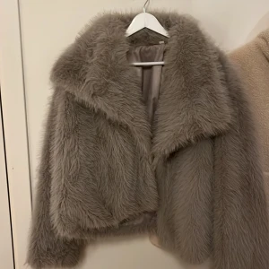 Beige pälsjacka - Säljer en supermjuk och fluffig beige pälsjacka med långa ärmar. Jackan har en elegant och lyxig look, perfekt för att hålla sig varm och stilren under kyliga dagar. Den har en klassisk design med en bred krage.
