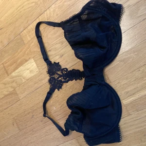 Svart spets-bh med broderad detalj - Elegant svart bh med spets och vacker broderad detalj i ryggen. Justerbara axelband och mjuka kupor för bekväm passform. Perfekt för att känna sig extra fin.