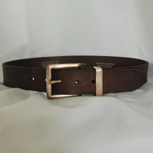 Vintage läderskärp  - Italienskt tillverkat brunt vintage läderskärp med snyggt slitage på metallspännet. Längd 75 cm