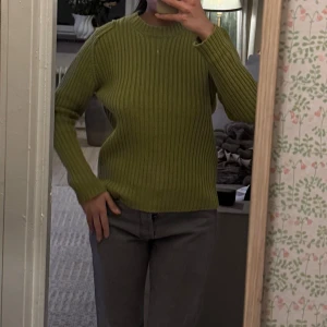 Grön ribbad tröja - Säljer en snygg grön ribbad tröja med långa ärmar. Perfekt för kyligare dagar och enkel att matcha med olika outfits. Tröjan har en klassisk rund halsringning och ger en stilren look. Jag är vanligtvis en xs/s i tröjor, denna har en lite oversized fit som sitter as nice 💖