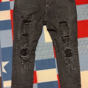 Svarta jeans från NVLTY - Snygga svarta jeans från NVLTY med mycket av slitningar. Med ett skönt stretch tyg som sitter tajt om bena. Dem har används sparsamt och är i fint skick, om du har frågor angående jeansen skicka bara ett meddelande✅