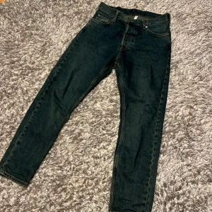 Svarta jeansbyxor från Apparel - Snygga svarta jeansbyxor från Apparel med klassisk femficksdesign. Byxorna har en rak passform och stängs med dragkedja och knapp. Perfekta för en stilren look.