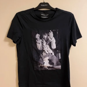 Svart t-shirt med tryck från Limitato - Snygg svart t-shirt från Limitato med ett coolt svartvitt tryck på framsidan. Perfekt för dig som vill ha en stilren men ändå unik look. T-shirten har en klassisk passform och är kortärmad.