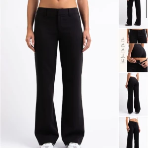 Svarta kostymbyxor - Snygga svarta kostymbyxor med låg midja och bootcut-stil. Perfekta för en stilren look. Byxorna har en klassisk design med knappar och dragkedja framtill. Endast använd 1 gång. Längden är extra stort st 32 köpte för 649kr