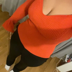 Orange ribbad tröja - Säljer en snygg orange,röd ribbad tröja med långa ärmar och en v-ringad design. Perfekt för att liva upp garderoben med en färgklick. Passar bra till både jeans och kjol. Hör av dig vid intresse! 🧡