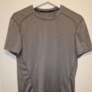 Grå t-shirt från Nike - Perfekt för träning med sin bekväma passform. Enkel och stilren design som funkar till det mesta.