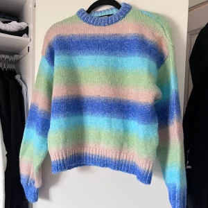 Randig stickad tröja (NY) - Säljer en mysig stickad tröja från BikBok i storlek S. Tröjan har ett färgglatt randigt mönster i blått, grönt och beige. Den har långa ärmar och ribbade muddar vid ärmslut och nederkant. Perfekt för en färgglad look! 🌈 Aldrig använd. Önskar du veta exakta mått? Tveka inte att höra av dig!
