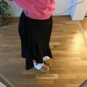 Volangkjol - Snygg svart kjol med knytning i midjan. Jättefint skick.Storlek m men passar de flesta då den är justerbar i midjan