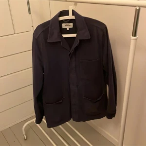 Mörkblå overshirt från Weekday - Säljer en stilren mörkblå overshirt från Weekday. Jackan har långa ärmar och två stora fickor framtill. Perfekt för lager-på-lager-stil och passar bra till både jeans och chinos.