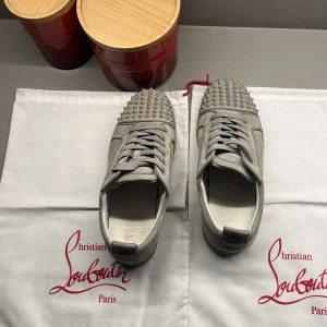 Christian Louboutin skor - Snygga grå sneakers från Christian Louboutin med coola nitar på ovansidan. Skorna har snörning och är tillverkade i ett stilrent grått material. Perfekta för att ge din outfit en edgy touch. De är i acceptabelt skick och använda försiktigt. Storlek 40 passar 40,5-41 hör va er vid intresse!🙌🏽✌🏼pris går att diskutera 