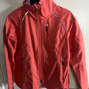 Rosa  jacka från CRW - Snygg rosa jacka från CRW med dragkedja och flera praktiska fickor. Perfekt för utomhusaktiviteter med sin sportiga design och bekväma passform. Jackan har långa ärmar och reflekterande detaljer för extra synlighet.