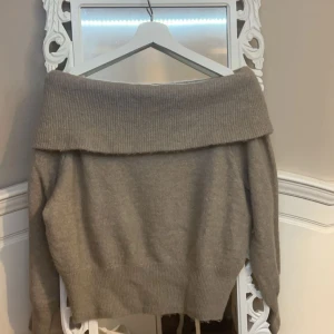 Beige offshoulder tröja från H&M - Säljer en stilren beige offshoulder tröja från H&M. Tröjan är stickad och har långa ärmar, perfekt för kyligare dagar. Den breda kragen ger en snygg och avslappnad look. Passar utmärkt till både jeans och kjol.