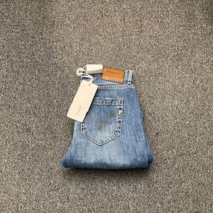 Snygga blå jeans från Dondup med klassisk femficksdesign och läderpatch med logga baktill. Perfekta för en stilren look.