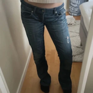 Blå boot cut jeans! - Snygga blå jeans. De har en låg midja och en bootcut-stil som ger en avslappnad look. Perfekta för en casual outfit.