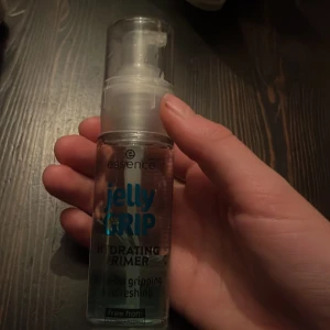 Jelly Grip Hydrating Primer från Essence - Essence Jelly Grip Hydrating Primer är en återfuktande primer med en geléliknande konsistens. Den kommer i en genomskinlig flaska med pump och är designad för att ge en fräsch och greppande bas för smink.