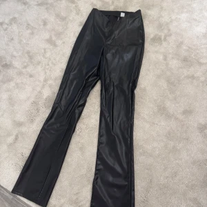 Svarta skinnbyxor  - Säljer ett par svarta skinnbyxor. Byxorna har en låg midja, raka ben och en snygg, stilren look. De är bara använda en gång annars helt nya. Priset kan diskuteras vid snabb affär. 