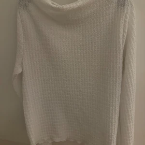 Vit långärmad tröja från 157 - Säljer en vit fladdrig långärmad tröja från 157 i storlek XL. Tröjan har ett unikt vågigt mönster i materialet och en rund hals. Perfekt för dig som gillar stilrena och enkla plagg med lite extra struktur. Passar dig som vill ha en bekväm och snygg look.