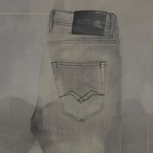 Grå Replay Grover jeans - Snygga grå jeans från Replay i modellen Grover. De har en straight/slim fit och är perfekta för en avslappnad stil. Midjemått är W30 och längd L32. Klassisk design och en diskret logga på baksidan. 