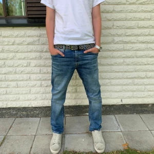 Blåa Jack & Jones jeans | Storlek 30/30 - Nästan splitternya Jack & Jones jeans. Snyggt slitna detaljer och femficksmodell. Perfekta för en avslappnad och tidlös stil. Litet sömfel som inte påverkar funktionen och hållbarheten på jeansen. Pris ej hugget i sten!