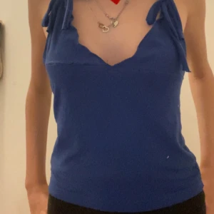 Blå linnetopp med knytband - Supersöt blå linne med två justerbara rosetter på som man kan ta bort ifall man vill. Den är gjort helt själv så den är inte helt perfekt,sömerna syns vid vissa ställen och det är pytte små hål vid några av ställerna som jag visa på bilden. Annars är den fin och perfekt för sommarn då den har en öppen rygg💕priset kan sänkas 