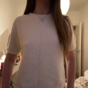 Beige stickad kortärmad tröja - Supermysig beige stickad tröja från Arket med rund hals och korta ärmar. Perfekt för lager-på-lager och har en enkel, clean look som funkar till jeans eller kjol. Materialet är mjukt och ger en chill vibe. Snygg att styla med smycken eller över en skjorta. Storlek 158/164 men passar xxs-s💞