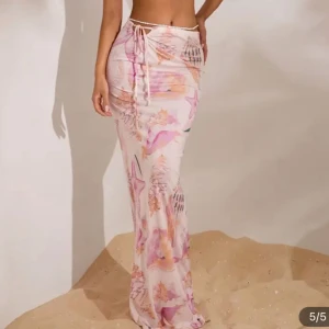 Pastellfärgad långkjol med snörning - Superfin långkjol i ljusa pastellfärger med snäckskalsmönster och snörning i midjan. Kjolen har en flowy passform. Materialet känns lätt och svalt mot huden.