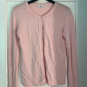Ljusrosa kofta från KappAhl XS - Säljer en söt ljusrosa kofta från KappAhl i storlek XS. Koftan har rund halsringning, långa ärmar och knappar framtill. Materialet är mjukt och stickat, perfekt för att ge din outfit en chill och feminin vibe. Inga defekter, normal i storleken🤗