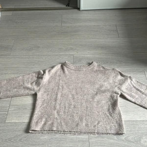 Beige stickad tröja från 157 XS - Mysig beige stickad tröja från 157 i storlek XS. Tröjan har en rund halsringning, ribbade muddar och lång ärm. Perfekt för lager-på-lager och chill dagar. Enkel och stilren design som funkar till allt.