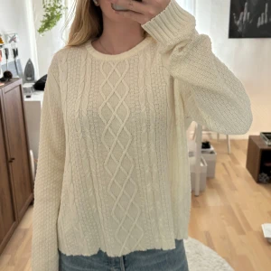 Vit stickad tröja , Hampton Republic - Off white stickad tröja från Hampton Republic i storlek L. Tröjan har ett snyggt flätmönster framtill och ribbade muddar vid ärmslut och hals. Croppad hemma. 