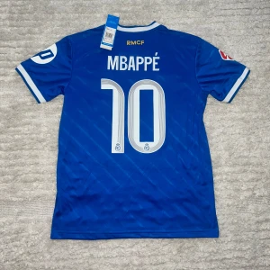 Mbappe real Madrid special edition 25/26 - Helt ny Mbappe tröja med prislapp, helt oanvänd. Med Laliga märke. Få tag på denna tröja innan Laliga starten!                    Anledningen till att dessa tröjor kostar lite mer än de andra är att jag betalade för FedEx expressfrakt och tull, och jag vill ge dig chansen att få tröjan innan ligan drar igång 🤝🏼  Mvh Zorro
