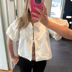 Vit topp med puffärm - Säljer denna jättefina topp med puffärm och knyten💕använd fåtal gånger