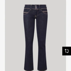 Mörkblå jeans med bootcut - Snygga mörkblå jeans med bootcut och kontrasterande sömmar. De har en klassisk femficksdesign och två knappar i midjan. Perfekta för en stilren look.