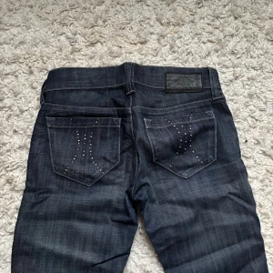 Mörkblå jeans med nitar - Snygga mörkblå jeans med stenar på baksidan ❤️måtten är , midjemåttet rakt över : 37,5 cm innerbenslängden:82 cm längden:102 cm❤️