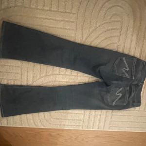Jätte snygga Nelly jeans - De populära Nelly jeansen med brodering på fickorna! Inte använda mycket alls. Midja rakt över: 37 cm Midjehöjd: 19 cm Innerbenslängd 80 cm