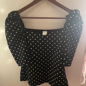 Svart prickig topp - Söt prickig topp från hm, använd ca 2 ggr och inga defekter. Passar super till alla tillfällen!