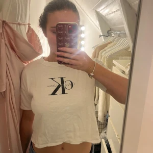 Vit t-shirt från Calvin Klein - Säljer en stilren vit t-shirt från Calvin Klein med deras ikoniska logga tryckt på framsidan!