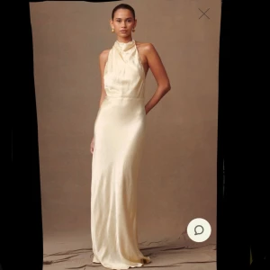 Ljusgul långklänning - Elegant ljusgul maxiklänning i satin med halterneck och öppen rygg. Klänningen har en smickrande passform och knappar längs ryggen för en stilren look. Passar perfekt till både bal och bröllop☀️klänningen är köpt för 1600 kr och säljer den eftersom den inte passade vad jag sökte. Detta är klänning 1/2 (beställde hem samma klänning i 2 storlekar)